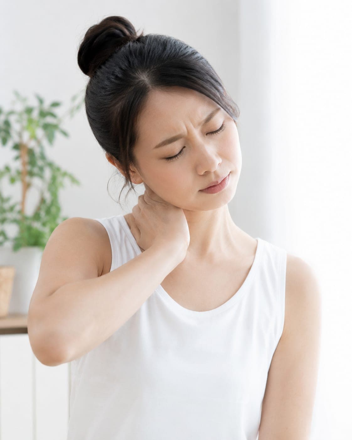 首の後ろを押さえる女性(イメージ)